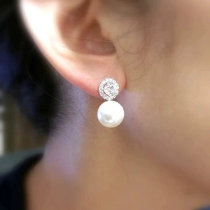 Elegant pearl stud earrings with sparkling cubic zirconia on a silver-toned metal setting