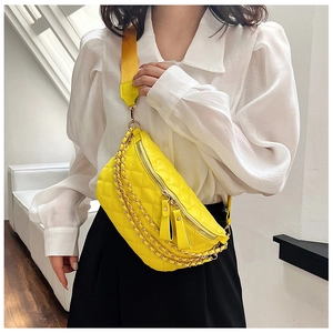 Detail of yellow quilted fanny pack with gold chains and fabric shoulder strap