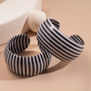 Set di bracciali rigidi larghi in acrilico con audaci strisce geometriche bianche e nere