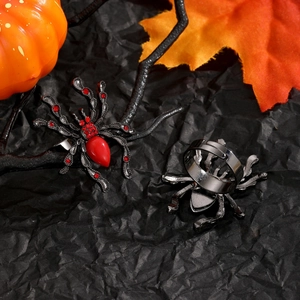 Détail d'une bague araignée punk avec cristaux rouges et anneau ajustable sur fond noir