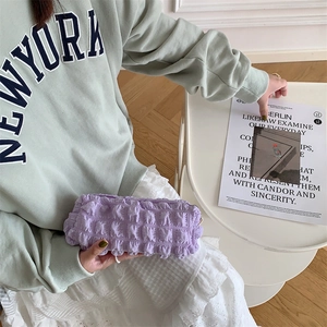 Detail of light purple soft bubble texture pouch held by a model for storage use