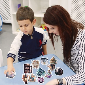 Lifestyle shot of realistic witch-themed stickers on a blue desk with people in background