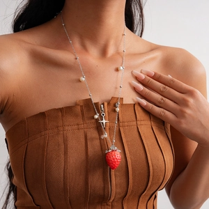 Asymmetric beaded pearl necklace featuring a red strawberry pendant and silver star charm