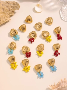 Detail of geometric triangle earrings set with colorful beads and gold tassels
