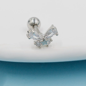 Macro shot of butterfly cartilage stud with pear zircons and star detail on silver metal