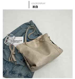 Detailed view of an off-white textured PU leather tote bag with pale gold hardware