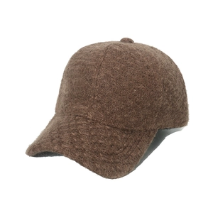 Detailed close-up of brown textured fuzzy knit baseball cap fabric for autumn and winter