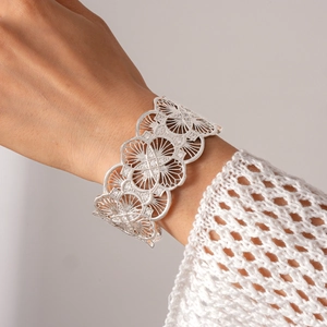 Detail of silver hollow flower cuff bracelet with sparkling zircon inlay for women
