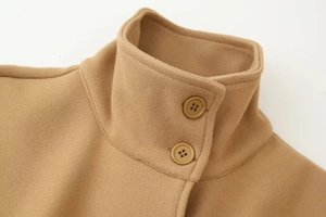 Detail of the high-quality camel wool coat featuring a stand-up collar and button closure