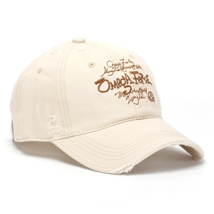 Détail de la casquette beige en coton avec broderie Omega Force et bordure effet usé