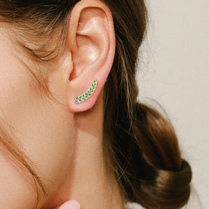 S925 sterling silver leaf stud earrings with green enamel on a female model's ear