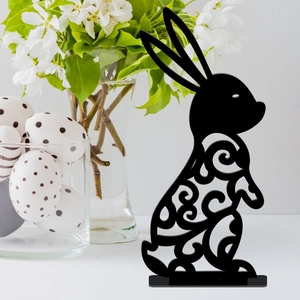 Detail of black acrylic Easter bunny with intricate hollow swirl patterns on a table