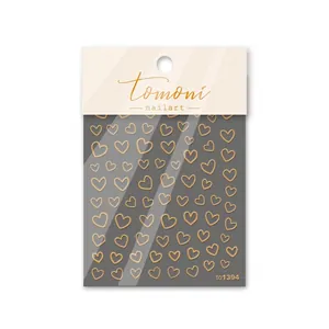 Primer plano de pegatinas doradas para uñas con corazones en embalaje profesional