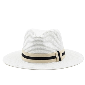 White straw panama hat with black striped band and classic wide brim fedora design