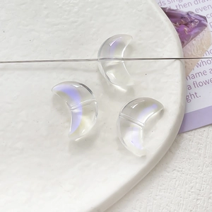 Macro shot of three crescent moon glass beads with a colorful aurora gradient effect
