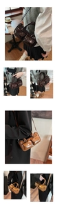 Detail of vintage brown saddle bag showing glossy leather texture and double front pockets