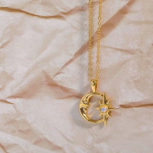 Minimalistische Goldkette mit hohlem Mond- und Stern-Opal-Anhänger auf Texturhintergrund
