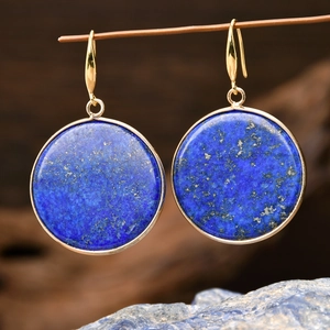 Macro detail of geometric lapis lazuli earrings with deep blue stone and gold metal