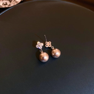 Macro shot of zircon clover studs with champagne imitation pearls in rose gold finish