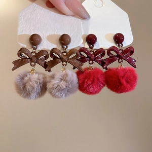Dettaglio orecchini a fiocco con pompon in peluche e aghi in argento S925, caffè e rosso