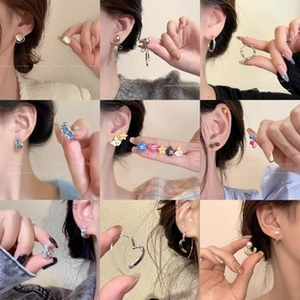 Detailed close-up of multiple heart-shaped earrings and studs in various colors