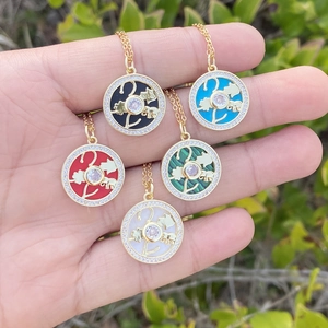 Close-up of five gold plated tree of life necklaces with colorful enamel pendants