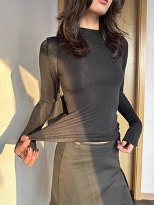 Detail view of high-elastic black wool-tencel knit top with mock neck and soft texture