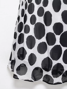 Close-up of black and white polka dot chiffon fabric showing soft drape and texture