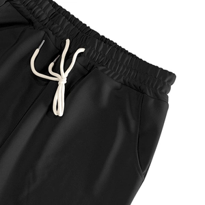 Détail du pantalon de jogging noir avec taille élastique et cordon de serrage crème