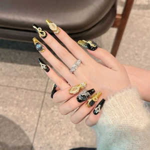 Handmade press-on nails in black and gold with 3D cat eye stones and flower ring