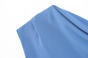 Macro shot of smooth blue fabric texture and precise stitching on asymmetrical shoulder