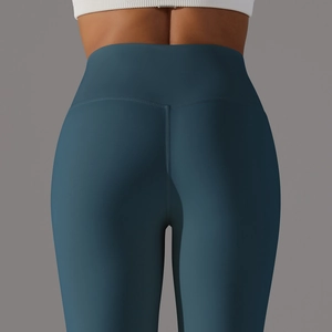 Detail shot of high-waist yoga pants in dark teal showing V-shape lifting back seam