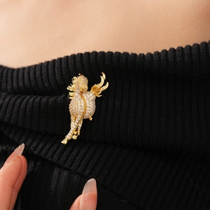 Detail of a vintage gold-plated seahorse brooch with pavé zircon on black knitwear