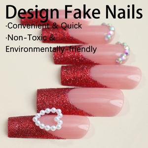 French red glitter press-on nails with heart pearl accent on warm beige background