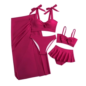 Flat lay detail of mother and daughter matching hot pink bikini set with floral skirt