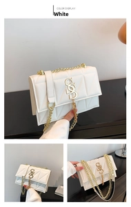 Detail of white quilted crossbody bag with golden S-buckle and elegant chain strap