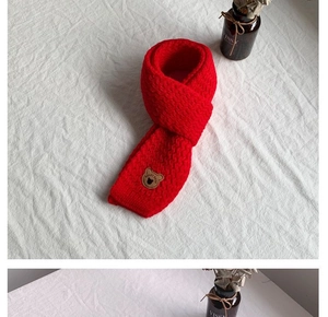 Dettaglio di sciarpa rossa in maglia per bambini con toppa a orsetto e ricamo BEARS BABY