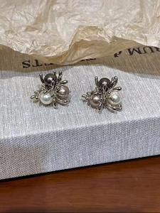 Detailed macro of silver vine earrings with grey champagne and white pearls