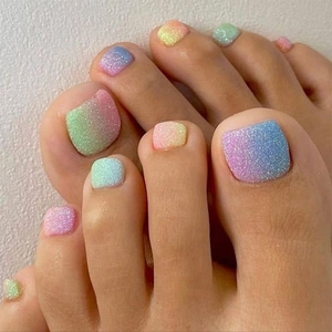 Detailed close-up of gradient pastel press-on toenails with subtle glitter finish