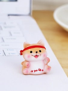 Miniature resin Shiba Inu figurine with motivational slogan on a white laptop keyboard