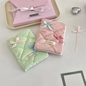 Detail of mint and pink quilted passport holders with satin bows and glossy finish