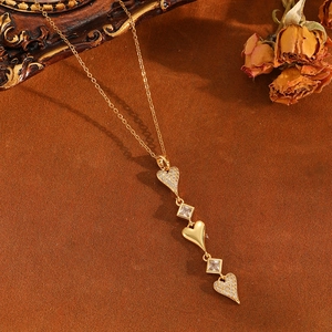 Détail du collier pendentif cœur doré avec pierres de zircon et accents floraux