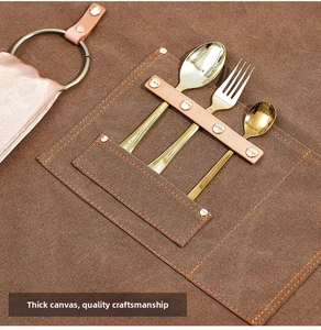 Detailed close-up of brown canvas apron featuring multi-pockets and leather straps