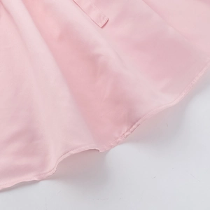 Detailed close-up of the light pink hemline on this elegant sleeveless dress