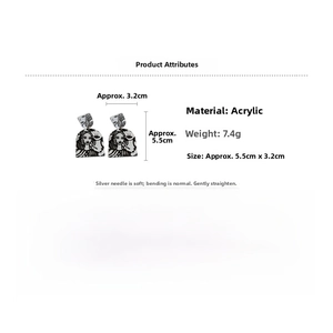 Detail showing acrylic earrings with black and white abstract line art and silver posts
