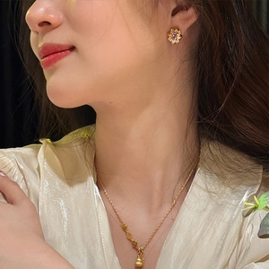 Close-up of 18K gold plated flower earrings with pink gemstones on female model