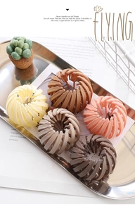 Close-up of five matte bird nest hair clips in various colors displayed on a metal tray
