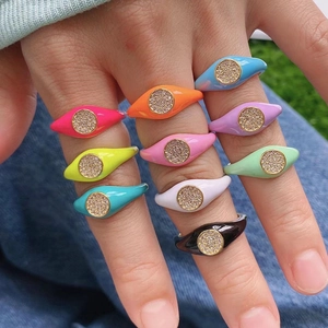 Colorful enamel copper rings set with micro-paved zircons shown in a hand-worn lifestyle scene