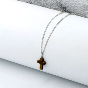 Detail view of tiger eye stone cross pendant on a fine silver metal necklace chain