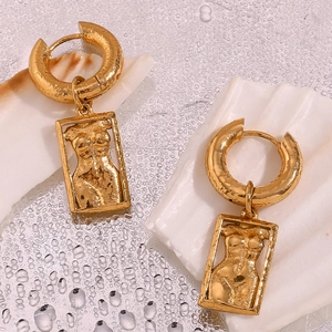 Artistic female body relief on a gold rectangular earring pendant displayed on a white shell